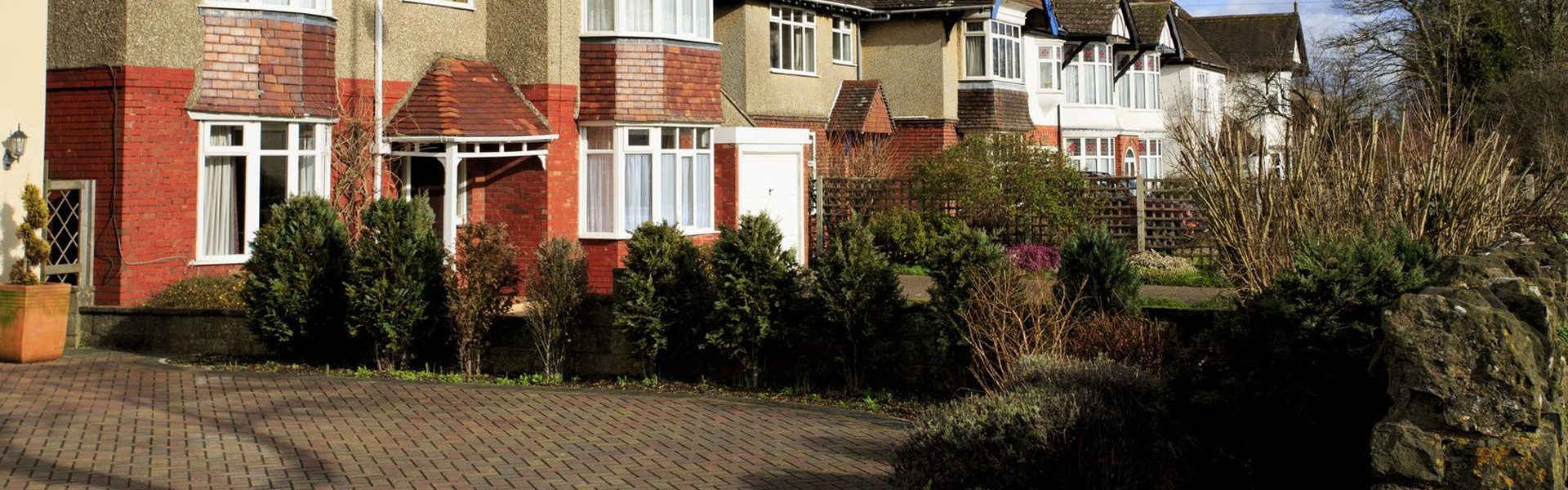 Block paved driveway sweeping up to a semi detached house