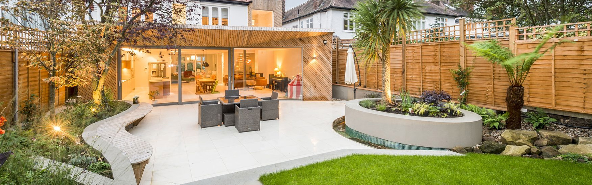 Large porcelain patio with a curved seating wall and planting